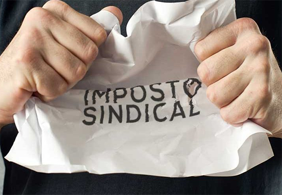 Pessoa amassando papel com o título "Imposto Sindical"